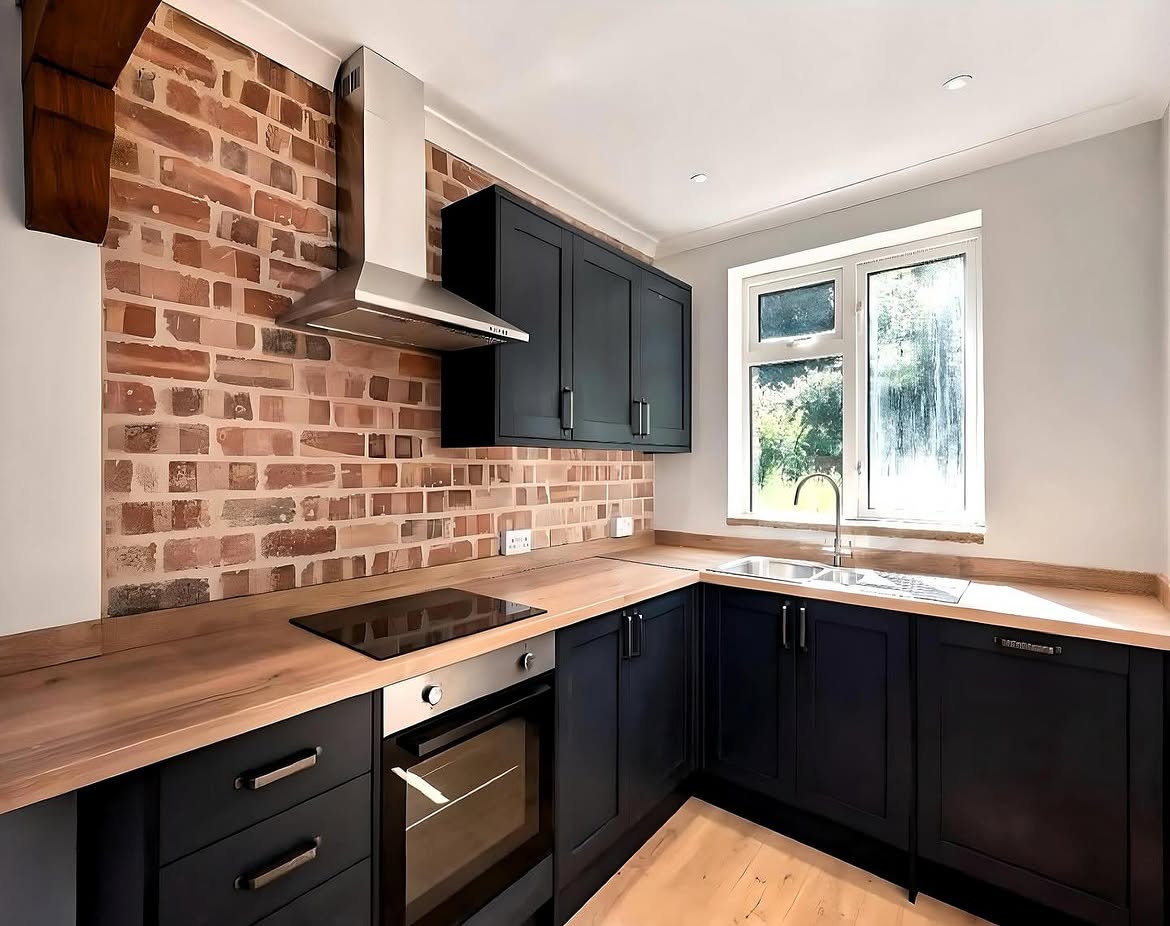 Navy doors, oak worktop and exposed brick in a finished Cobie kitchen